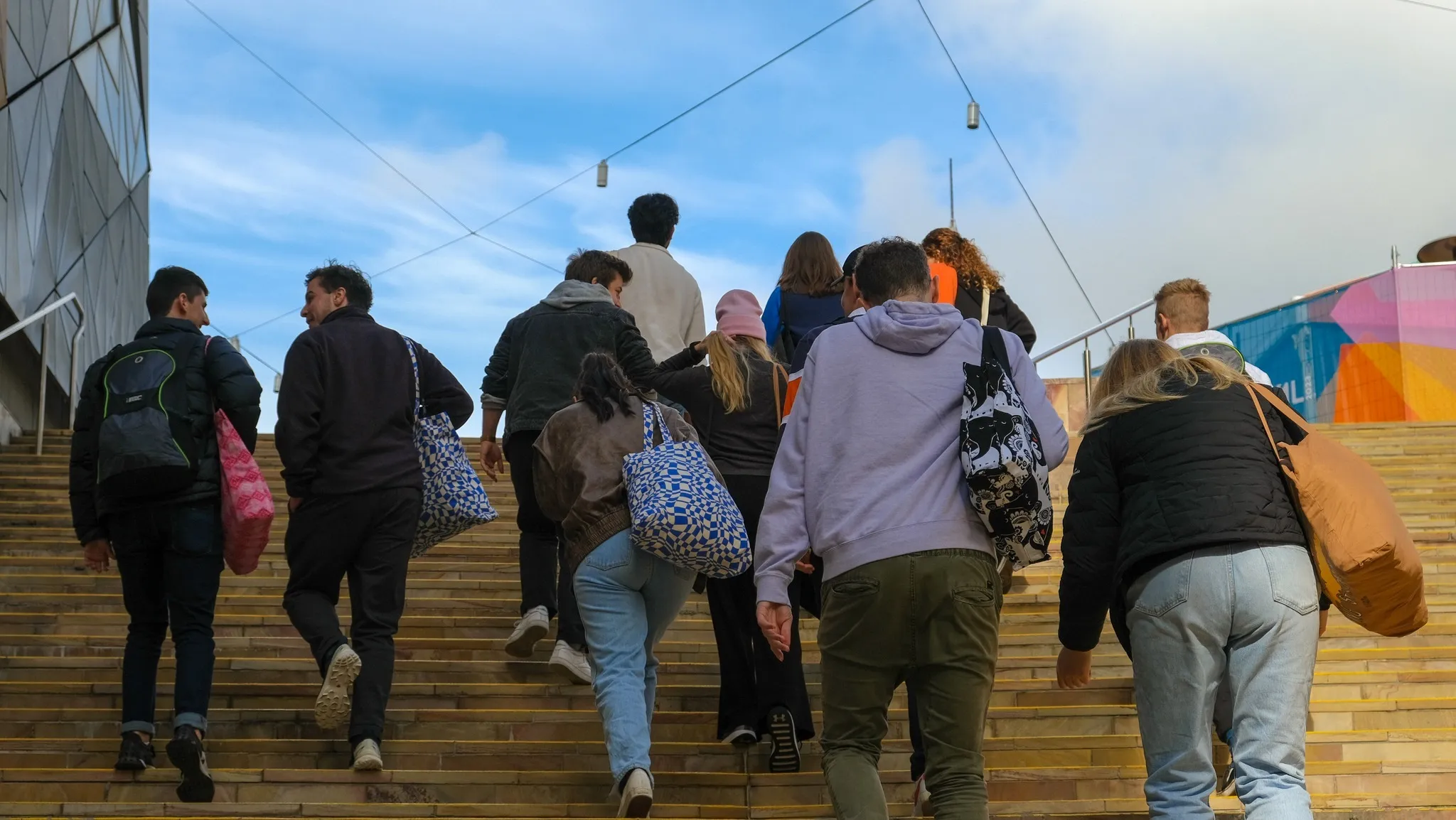 Mobilise outreach volunteers carrying bags up stairs in Melbourne CBD